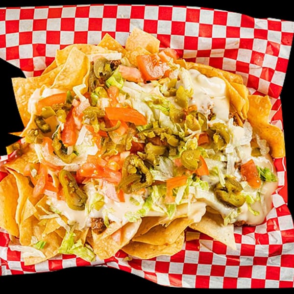 Loaded nachos with cheese sauce, ground beef, lettuce, tomatoes, and jalapeños in a red checkered basket.