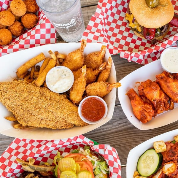 A Mixed Up Burgers spread with fried fish, shrimp, wings, a burger, and hush puppies.