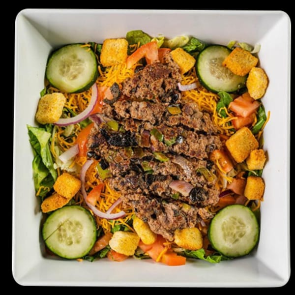 Mixed Up Burgers' taco salad with ground beef, cheese, lettuce, tomatoes, cucumbers, and croutons.