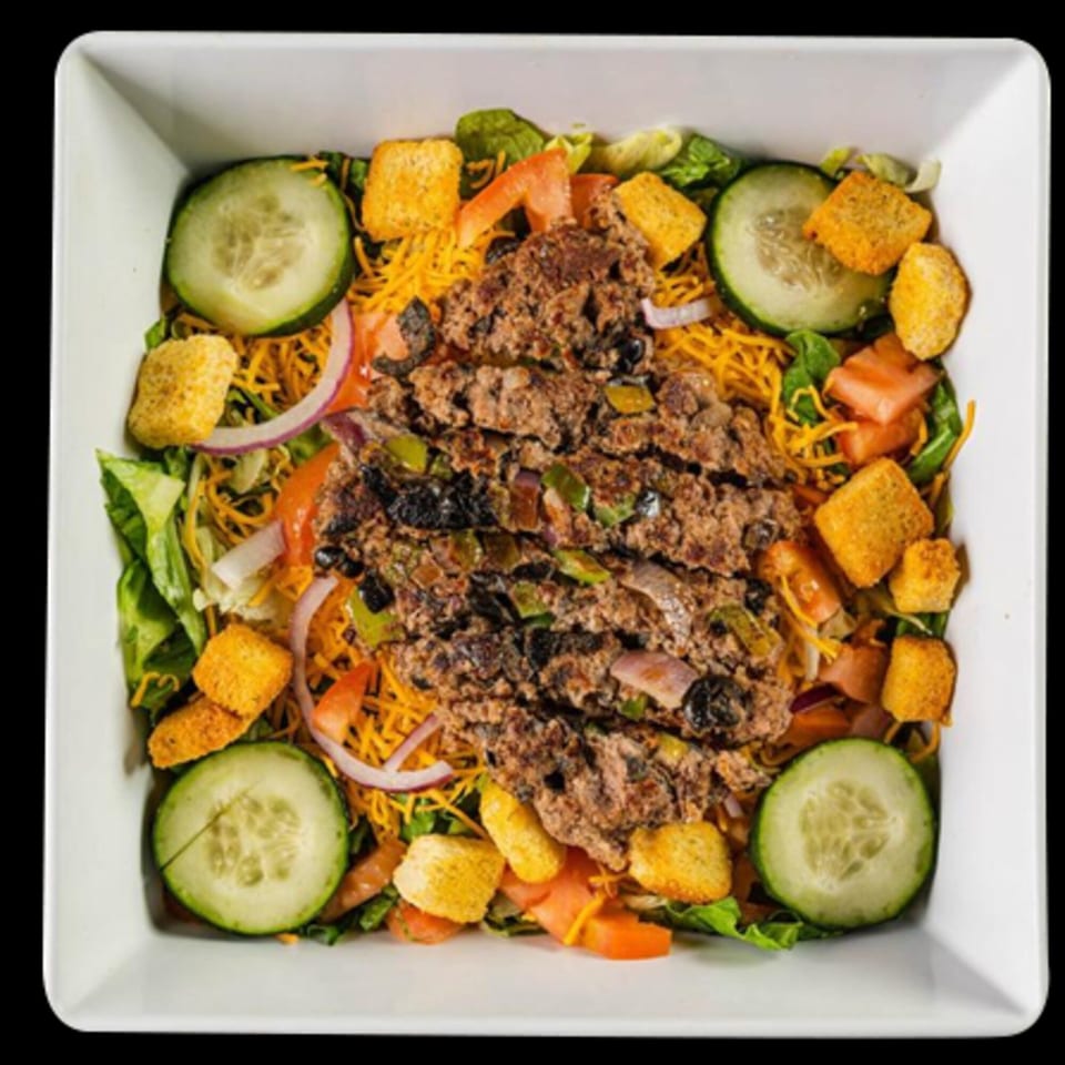 Mixed Up Burgers' taco salad with ground beef, cheese, lettuce, tomatoes, cucumbers, and croutons.